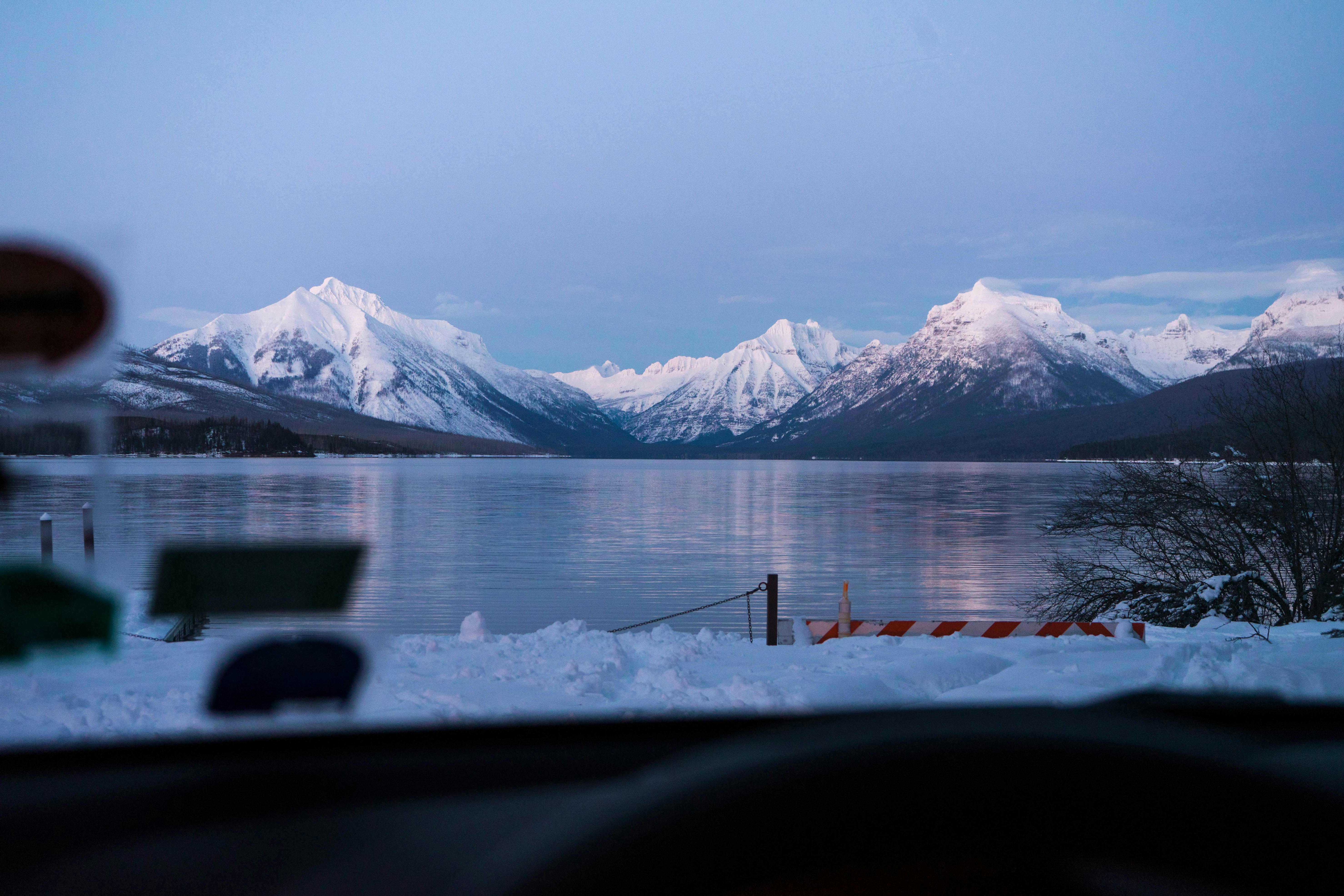 snow covered mountain near body of water during daytime